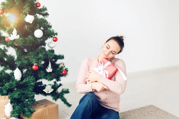 Weihnachten, Weihnachten, Winter, Glückskonzept - Mädchen öffnet ein Geschenk vor dem Hintergrund des Weihnachtsbaums. glückliche junge Frau feiert Weihnachten — Stockfoto