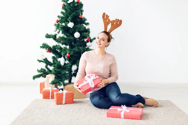 Christmas, x-mas, winter, happiness concept - girl opens a gift against the background of the Christmas tree. Happy young woman celebrating Christmas — Φωτογραφία Αρχείου