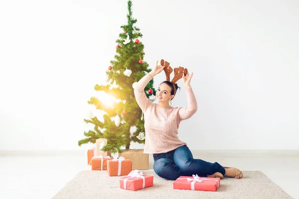 Christmas, x-mas, winter, happiness concept - girl opens a gift against the background of the Christmas tree. Happy young woman celebrating Christmas — Φωτογραφία Αρχείου