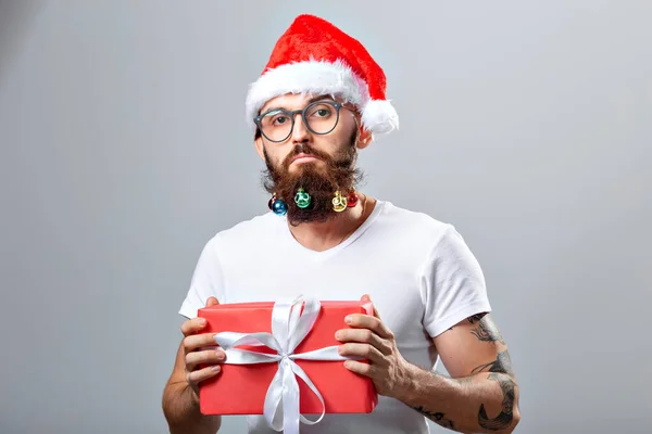 Christmas, holidays, barbershop and style concept - young handsome bearded santa claus man with many small christmas baubles in long beard — Stockfoto