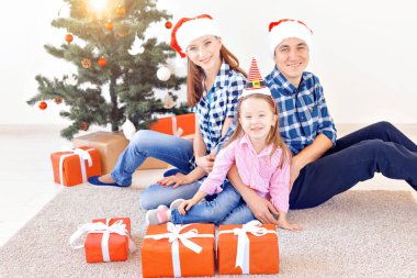 Noel ve Noel konsepti - Aile Noel hediyesini ağacın önünde açıyor