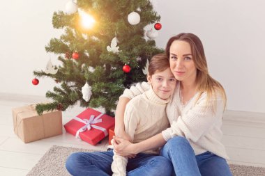 Bekar ebeveyn ve tatil konsepti - Noel arifesinde evde Noel 'i kutlayan anne ve çocuğun portresi