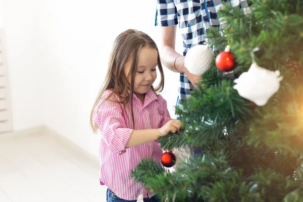 假日、父母和欢庆的概念- -快乐的家庭装饰着圣诞树，客厅里有白色背景的灌木 — 图库照片