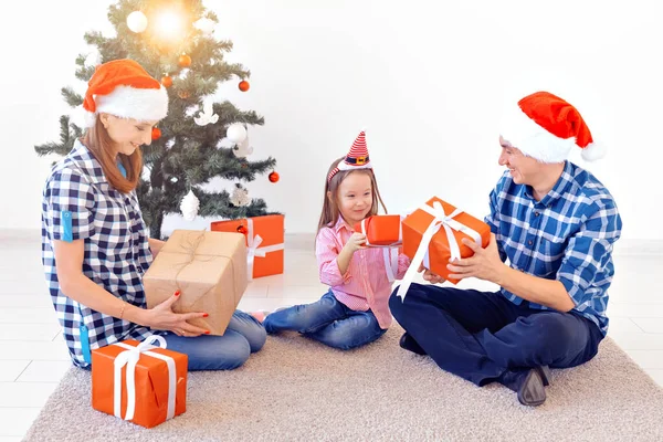 Рождество и праздничная концепция - Открытие рождественских подарков перед елкой — стоковое фото