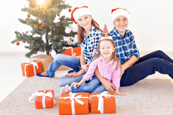 Vánoční a prázdninový koncept - Rodinné otevírání vánočních dárků před stromem — Stock fotografie