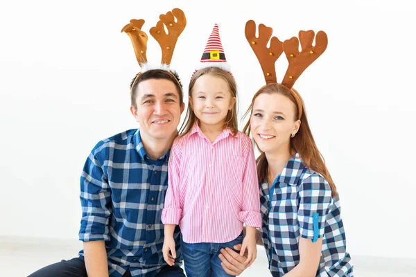Concepto de vacaciones de invierno: familia navideña con cuernos de Santa Sombrero y ciervo. Celebración familiar sonriente — Foto de Stock