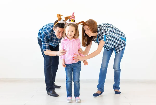 Concepto de vacaciones de invierno: familia navideña con cuernos de Santa Sombrero y ciervo. Celebración familiar sonriente — Foto de Stock