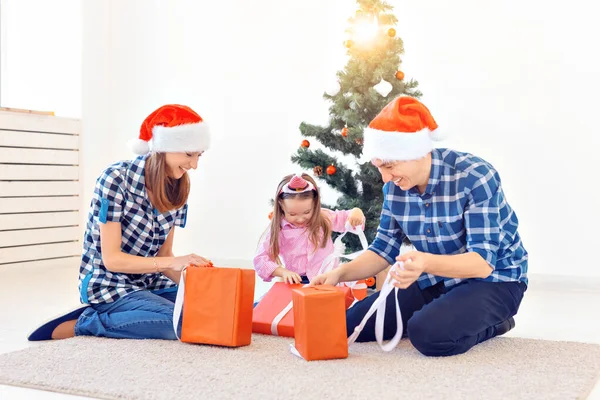 休日とプレゼントのコンセプト – クリスマス時に幸せな家族のオープニングギフトの肖像画 — ストック写真