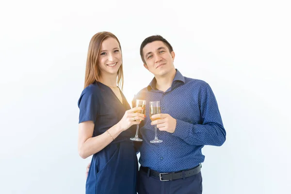 Uomo e donna che festeggiano il Natale o il Capodanno con bicchieri di champagne su sfondo bianco — Foto Stock