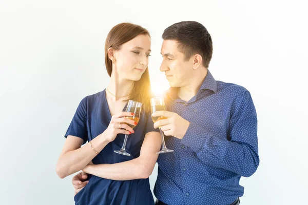 Άνδρας και γυναίκα γιορτάζει τα Χριστούγεννα ή την παραμονή της Πρωτοχρονιάς κόμμα με ποτήρια σαμπάνιας σε λευκό φόντο — Φωτογραφία Αρχείου