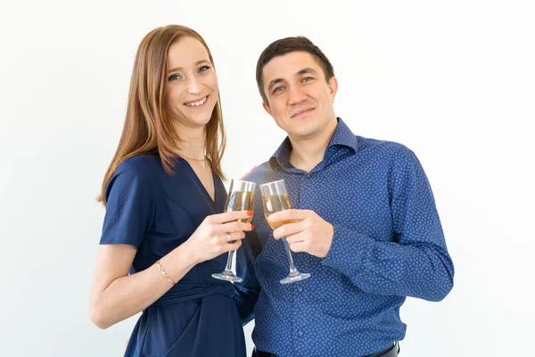 Άνδρας και γυναίκα γιορτάζει τα Χριστούγεννα ή την παραμονή της Πρωτοχρονιάς κόμμα με ποτήρια σαμπάνιας σε λευκό φόντο — Φωτογραφία Αρχείου