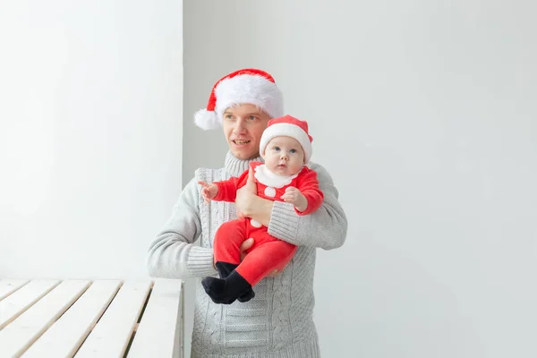 Ojcostwo i święto koncepcja - Ojciec ze swoim małym chłopcem na sobie Santa kapelusze świętowania Bożego Narodzenia — Zdjęcie stockowe