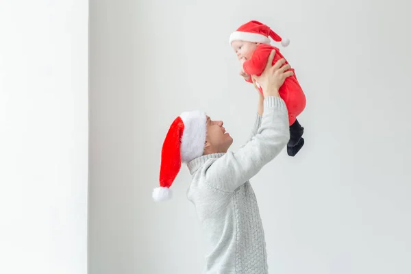 Ojcostwo i święto koncepcja - Ojciec ze swoim małym chłopcem na sobie Santa kapelusze świętowania Bożego Narodzenia — Zdjęcie stockowe
