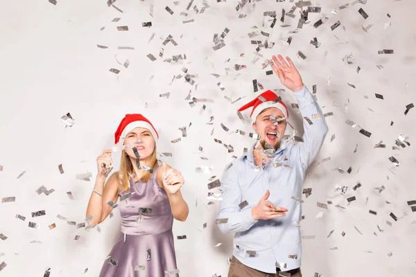 Año nuevo, Navidad y concepto de fiesta - Jóvenes alegres bañados con confeti sobre un fondo blanco . — Foto de Stock