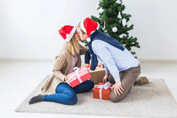 Conceito de feriados - Doce casal abrindo presentes de Natal, sentado na sala de estar — Fotografia de Stock