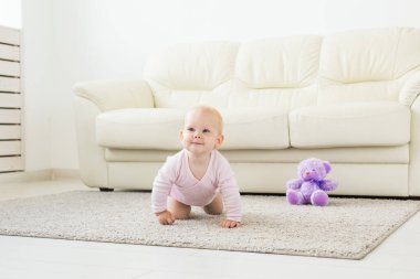 güzel gülümseyen bebek ilk kez sürünerek.