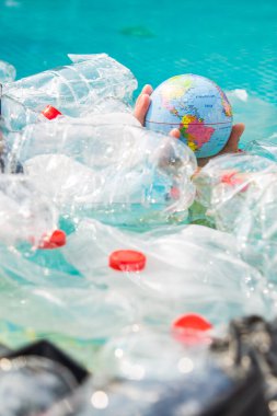 Ufa, Rusya - 25 Temmuz 2019 : Çöp sorunu, plastik geri dönüşüm, kirlilik ve çevre kavramı - Su ortamında plastik çöp kirliliği, Dünya küre çöp içinde yüzen