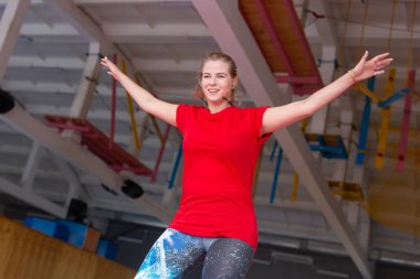 Fitness, eğlence, eğlence ve spor aktivite konsepti - Genç mutlu kadın kapalı bir trambolin üzerinde atlama