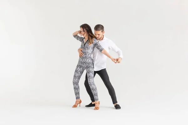 Концепция социального танца - активные счастливые взрослые танцуют бачата вместе на белом фоне с копировальным пространством — стоковое фото