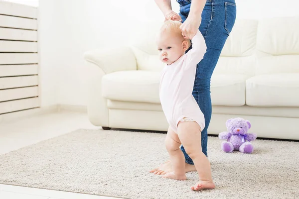 Bebê dando os primeiros passos com as mães ajuda em casa — Fotografia de Stock