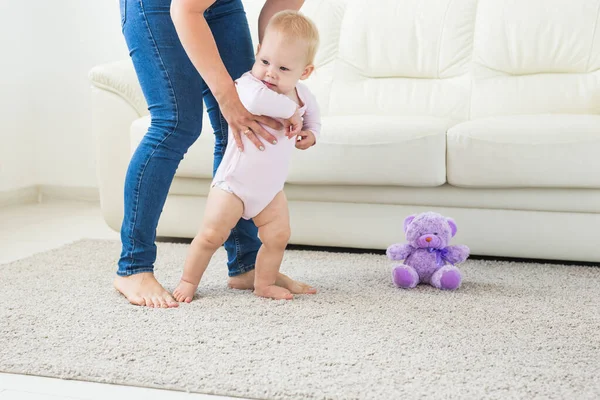 Baby tar första steg med mödrar hjälp hemma — Stockfoto