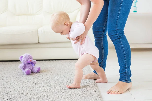 Kleine baby meisje eerste stappen met de hulp van moeder — Stockfoto