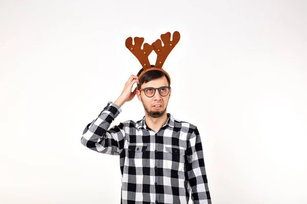 Kerst, vakantie en grappig concept - man met hertenhoorns en rudolf nous op witte achtergrond — Stockfoto