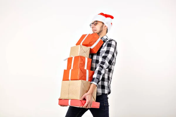 Vakantie en presenteert concept - Grappige man in kerstmuts met veel geschenkdozen op witte achtergrond met kopieerruimte — Stockfoto