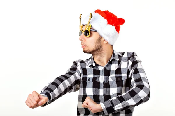 Portrait of a funny young man in Santa Claus hat and beard on white background. Christmas. — Stock Photo, Image