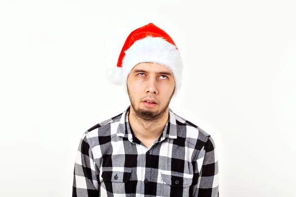 X-mas, téli ünnepek és az emberek koncepció - vicces ember Santa Claus kalap felett fehér háttér — Stock Fotó