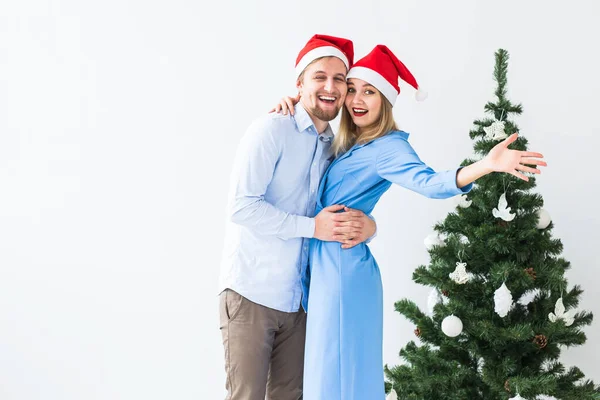 Holidays and celebration concept - Young couple celebrating Christmas at home