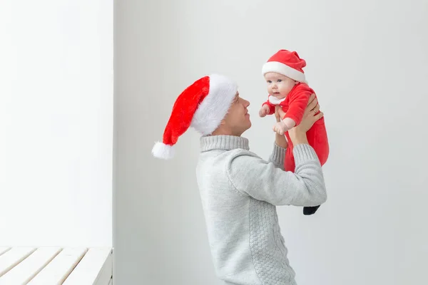 Ojcostwo i święto koncepcja - Ojciec ze swoim małym chłopcem na sobie Santa kapelusze świętowania Bożego Narodzenia — Zdjęcie stockowe