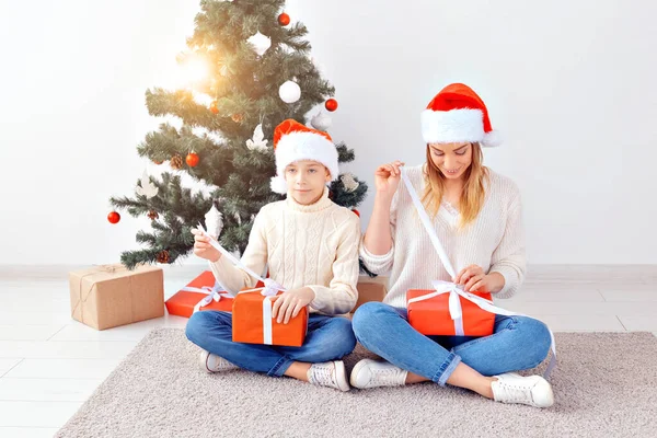 Концепция одиноких родителей и праздников - портрет матери и сына, празднующих Рождество дома в канун Рождества — стоковое фото