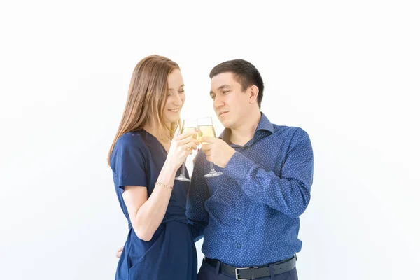 Homem e mulher comemorando a festa de Natal ou Ano Novo com copos de champanhe no fundo branco — Fotografia de Stock