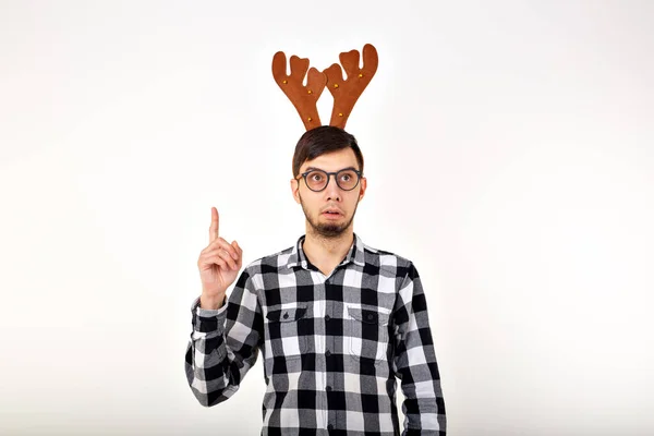 Kerst, vakantie en grappig concept - man met hertenhoorns en rudolf nous op witte achtergrond — Stockfoto