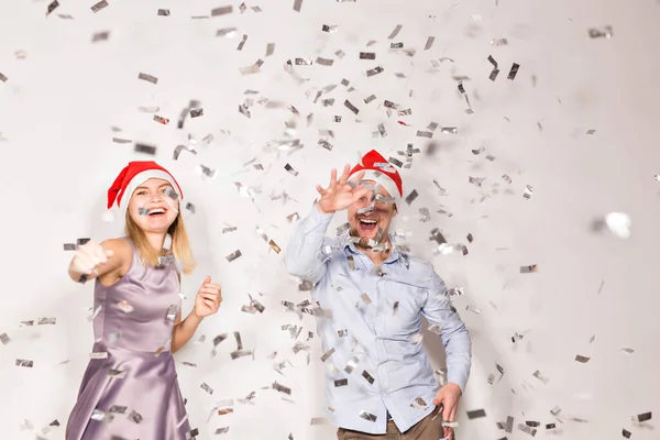 Ano Novo, Natal e conceito de festa - Jovens alegres banhados com confetes em um fundo branco . — Fotografia de Stock