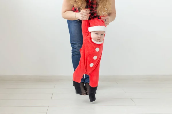 Children, childhood and holidays concept - baby in christmas clothes making first steps — Stock Photo, Image