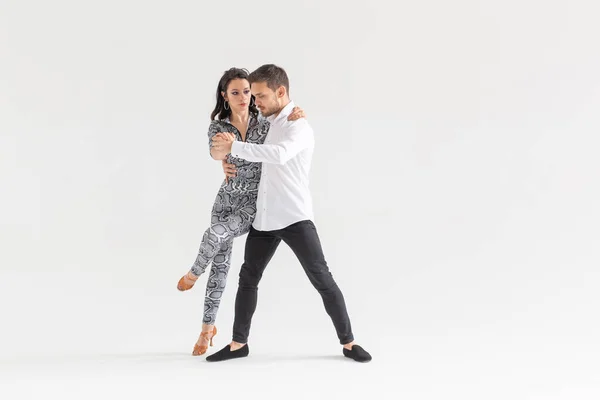 Dança social, bachata, kizomba, zouk, conceito de tango - Homem abraça mulher enquanto dança sobre fundo branco com espaço de cópia — Fotografia de Stock