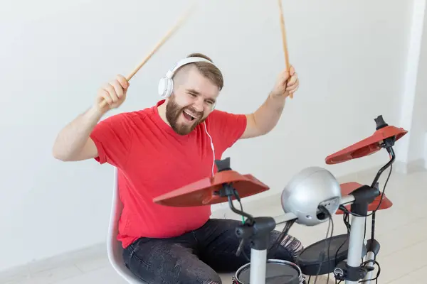 Человек в красной футболке, играющий на электронном барабане — стоковое фото