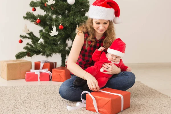 Rodinný, dětský a vánoční koncept - Portrét šťastné matky a roztomilého miminka v obleku Santy — Stock fotografie