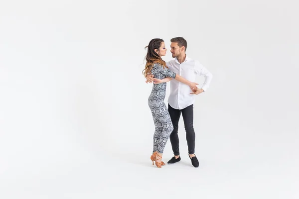 Giovane coppia che balla bachata, merengue, salsa. Due posa eleganza su sfondo bianco con copyspace — Foto Stock