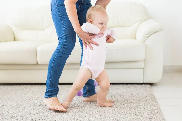 Bebê dando os primeiros passos com as mães ajuda em casa — Fotografia de Stock