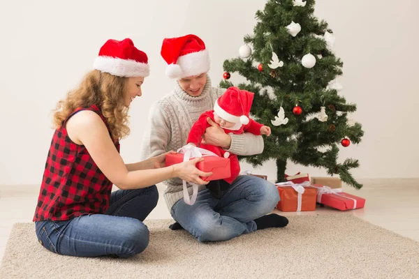 Счастливая пара с ребенком празднуют Рождество вместе дома . — стоковое фото