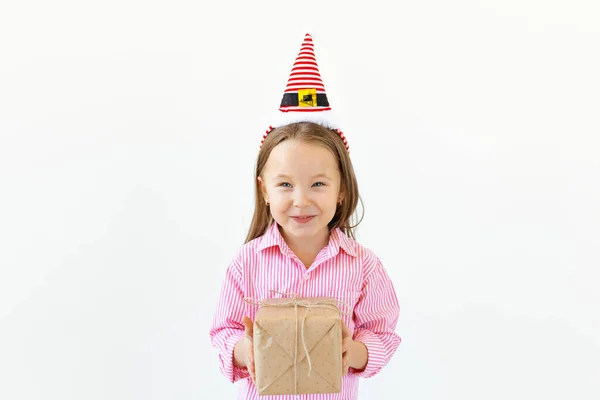 圣诞观念- -快乐的小女孩带着礼品盒笑着，背景为白色，有复制空间 — 图库照片