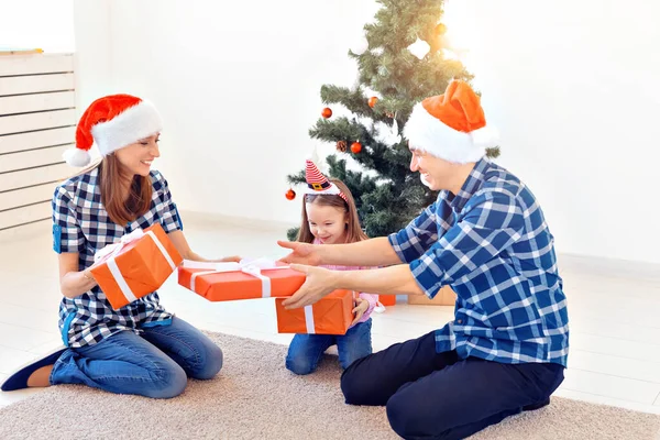 Vacaciones y presenta el concepto - Retrato de una familia feliz regalos de apertura en época de Navidad — Foto de Stock