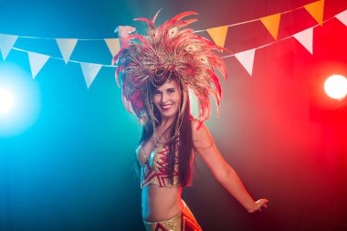 Karnaval, oryantal dans ve tatil konsepti - Altın kostüm giyen ve gülümseyen güzel kadın samba dansçısı