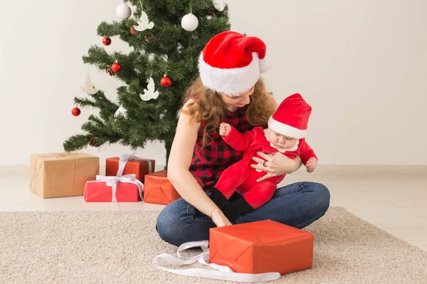 Rodzina, dzieciństwo i koncepcja Bożego Narodzenia - Portret szczęśliwej matki i uroczego dziecka w garniturze Mikołaja — Zdjęcie stockowe