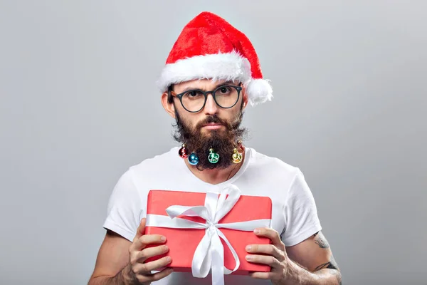 Navidad, vacaciones, barbería y concepto de estilo - joven guapo barbudo santa claus hombre con muchas pequeñas bolas de Navidad en barba larga —  Fotos de Stock