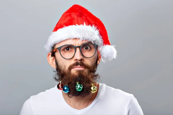 Navidad, vacaciones, barbería y concepto de estilo - joven guapo barbudo santa claus hombre con muchas pequeñas bolas de Navidad en barba larga —  Fotos de Stock