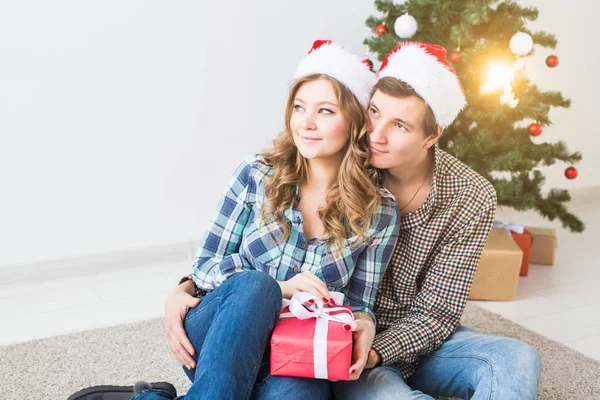 Famiglia, x-mas, vacanze invernali e concetto di persone - coppia felice che si abbraccia vicino all'albero di Natale a casa — Foto Stock